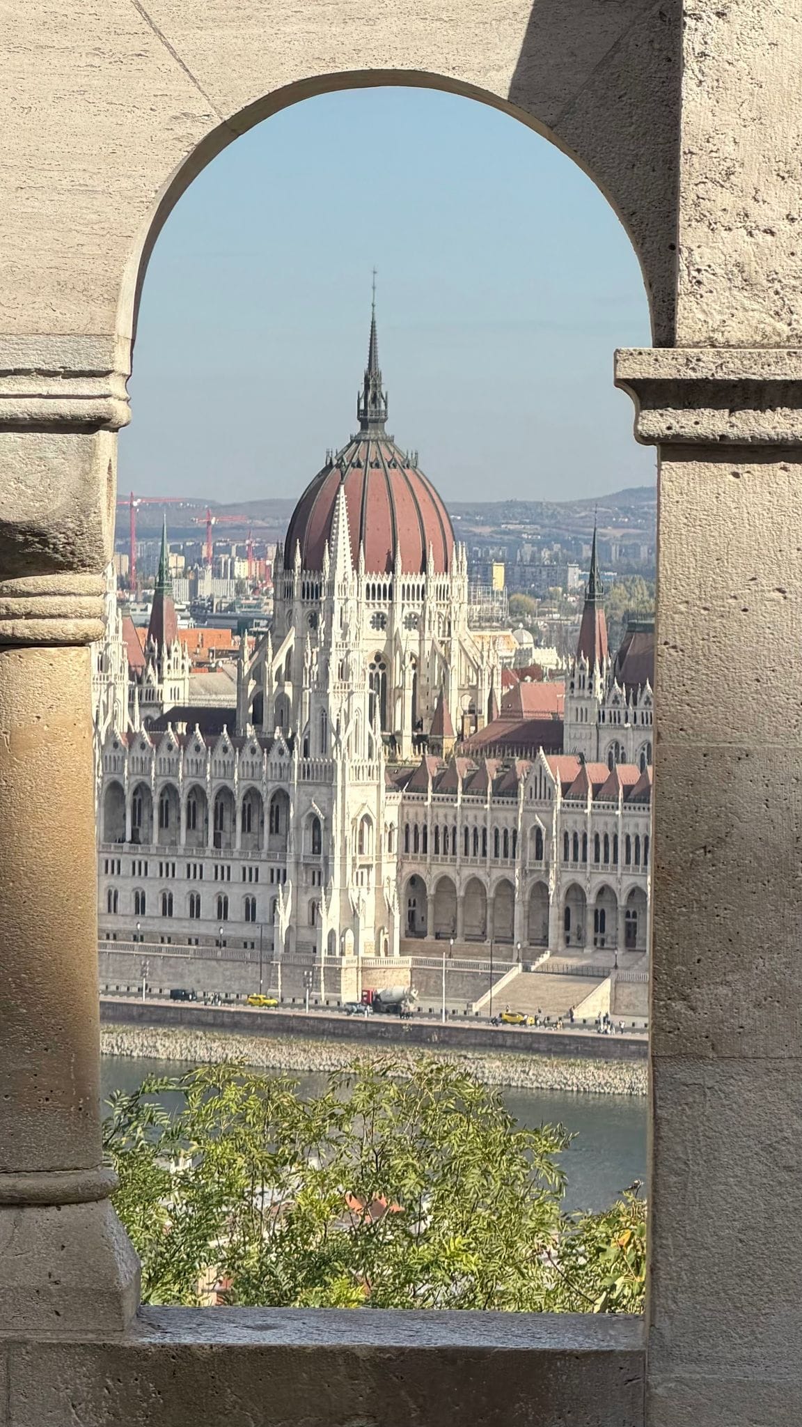 The Parliament dome framed by a stone arch of Fisherman's Bastion