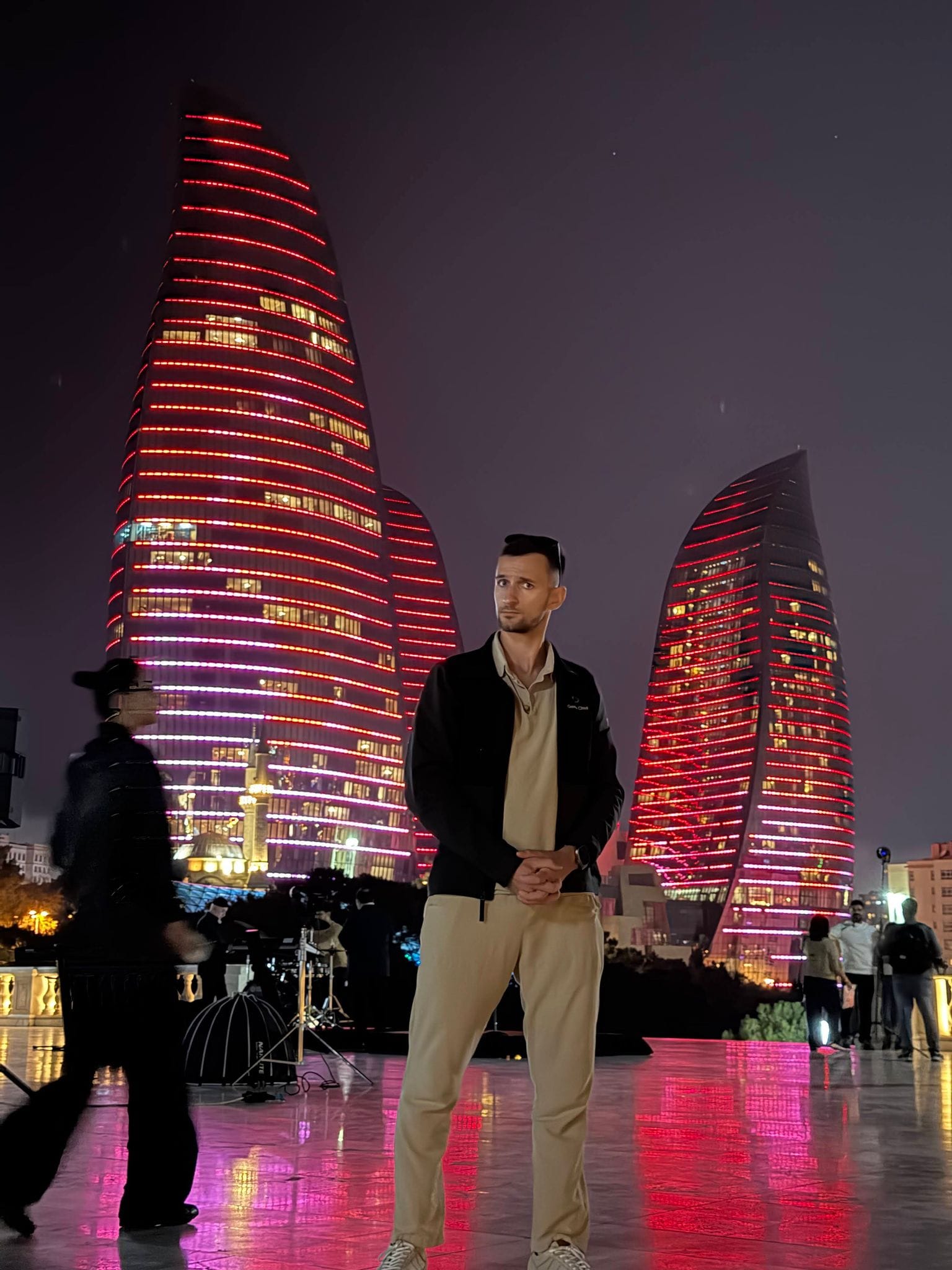 Nikita standing in front of the red-lit Flame Towers in Highland Park