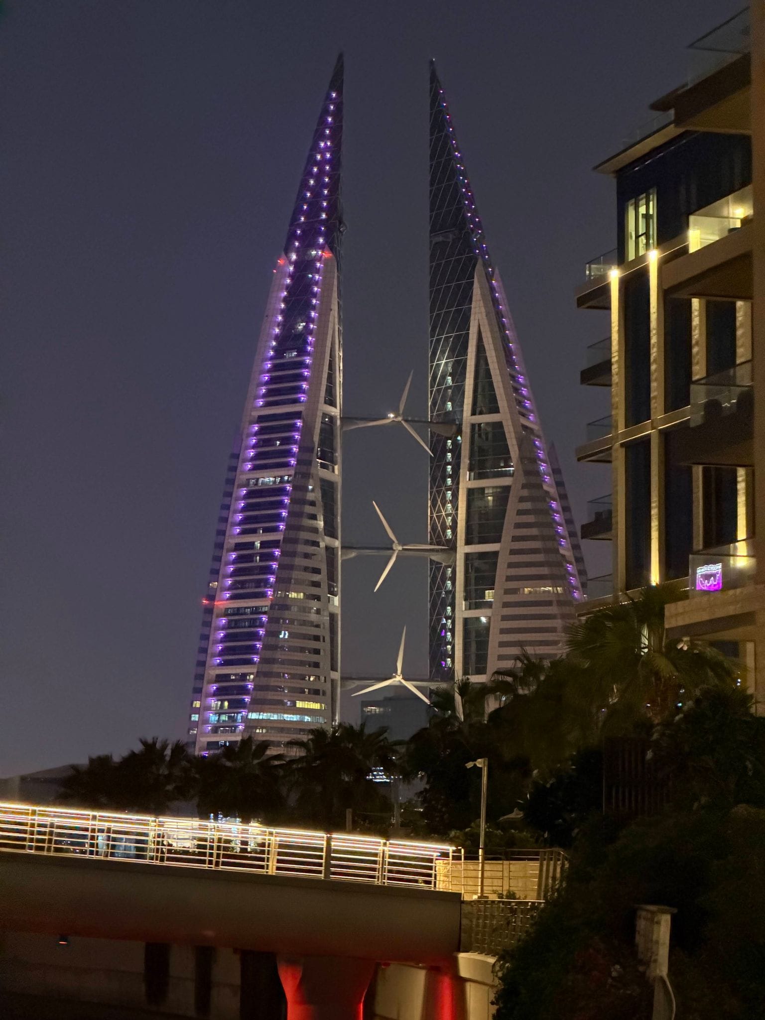 Вежі Bahrain World Trade Center уночі у фіолетовій підсвітці
