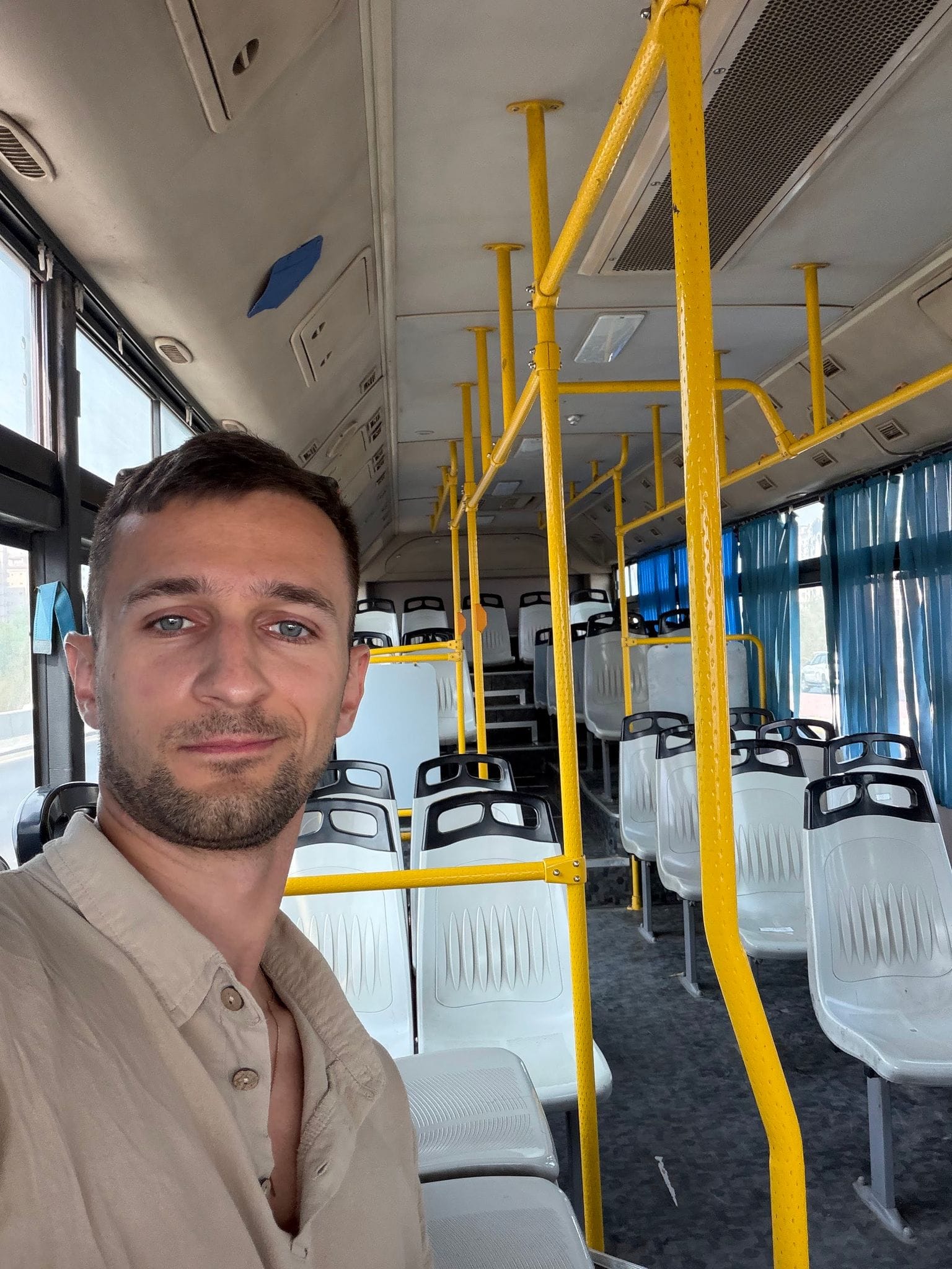 Селфі в порожньому автобусі до аеропорту Кувейту, позаду ряди порожніх сидінь